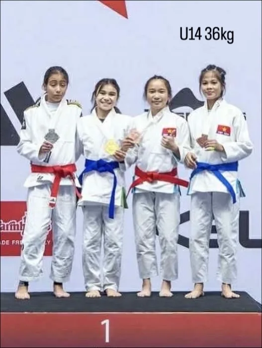 Bailey Heinsohn on the podium after winning U14 Female -36 kg Gi gold at the 2025 JJIF World Championships in Bangkok, Thailand.