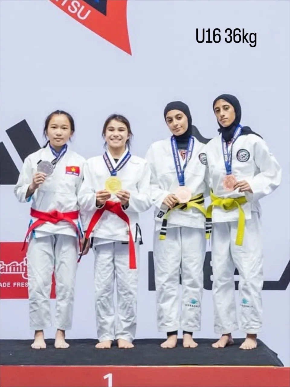 Bailey Heinsohn on the podium after winning U16 Female -36 kg Gi gold at the 2025 JJIF World Championships in Bangkok, Thailand.