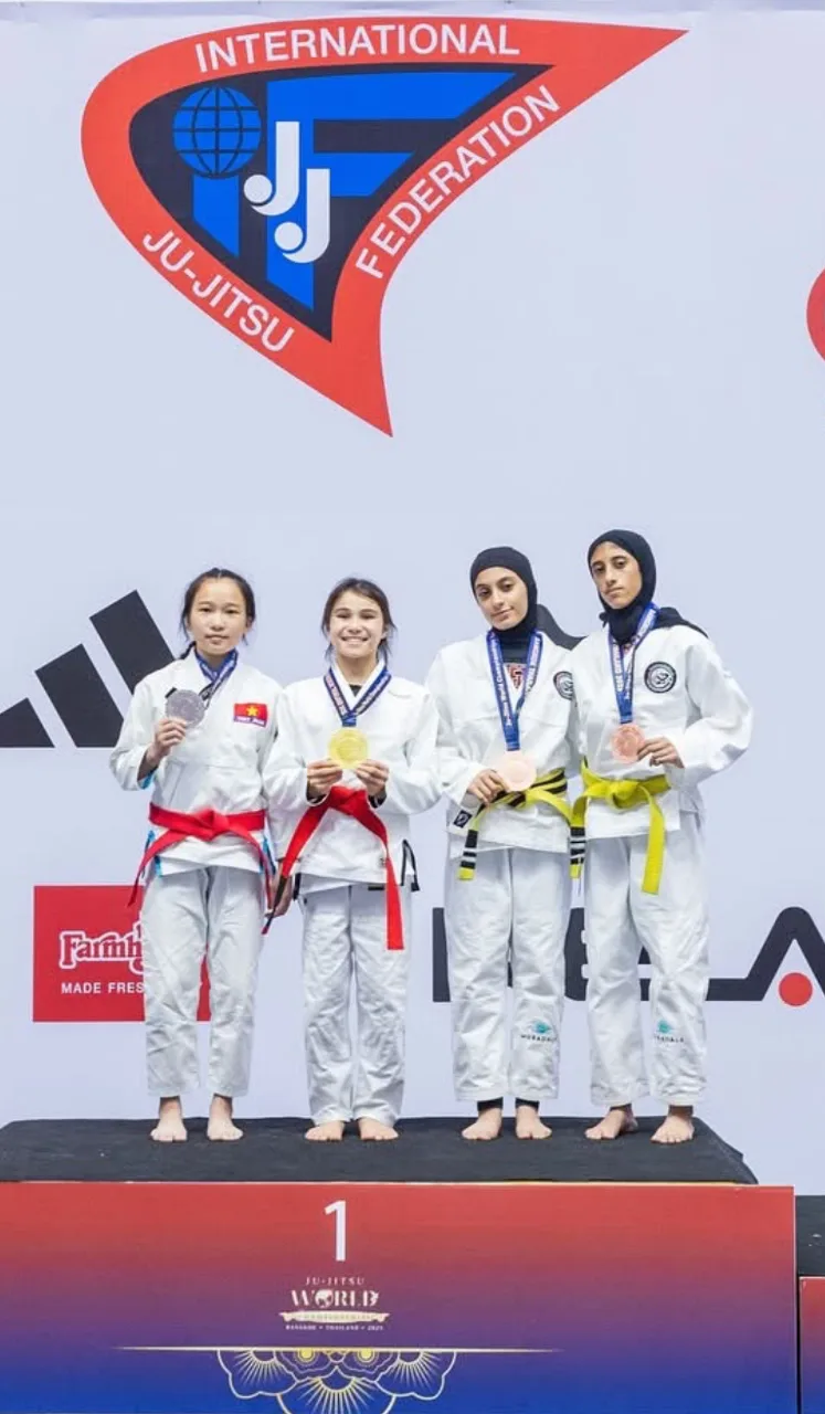 Bailey Heinsohn standing on the podium after winning the U16 Gi division at the 2025 JJIF World Championships in Thailand.