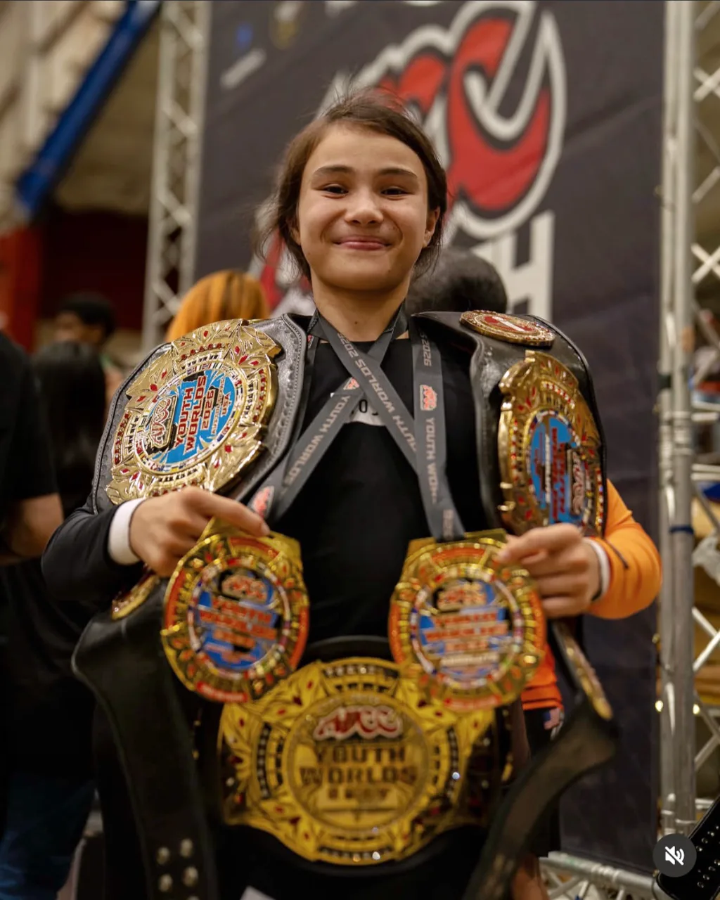 Bailey Heinsohn holding her championship belts and medals after winning double gold at the 2026 ADCC Youth World Championships in Austin, Texas.