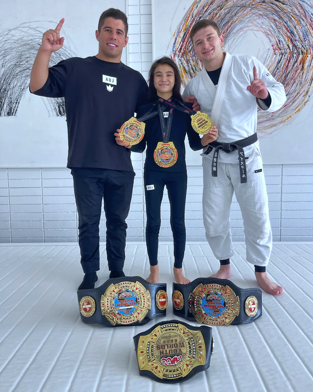 Bailey Heinsohn holding ADCC championship belts and medals after becoming a two-time ADCC Youth World Champion in 2026.